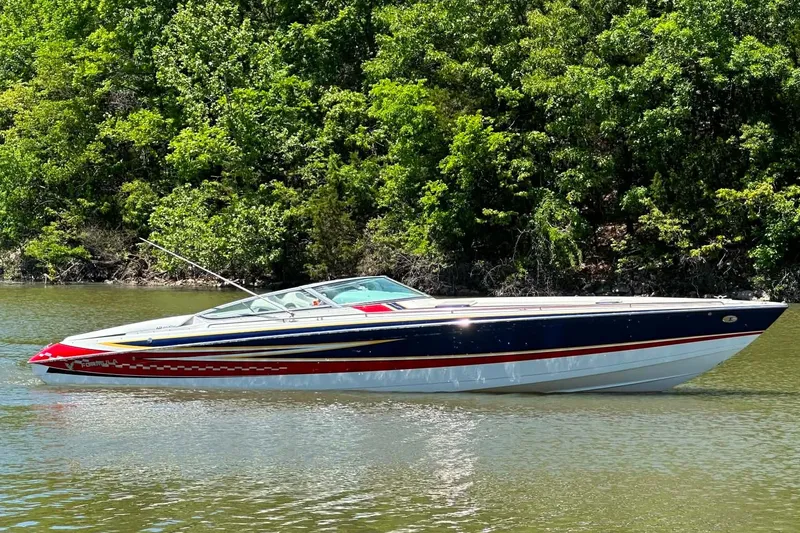 Slide: The Image of 2007 Formula 353 FASTech boat on calm water, surrounded by lush green trees. - 1