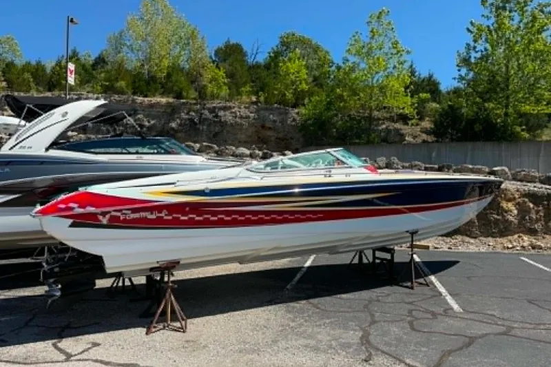 Slide: The Image of 2007 Formula 353 FASTech boat displayed outdoors on stands, vibrant design, sunny day. - 5