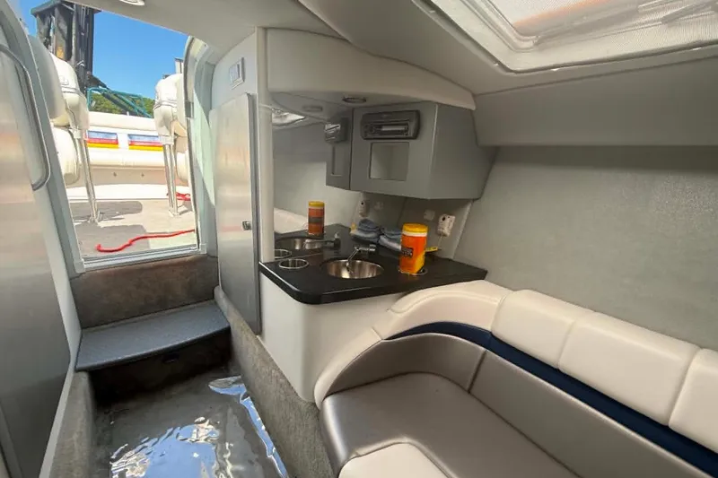 Slide: The Image of Interior of a 2007 Formula 353 FASTech boat, featuring a compact kitchenette and seating area. - 9