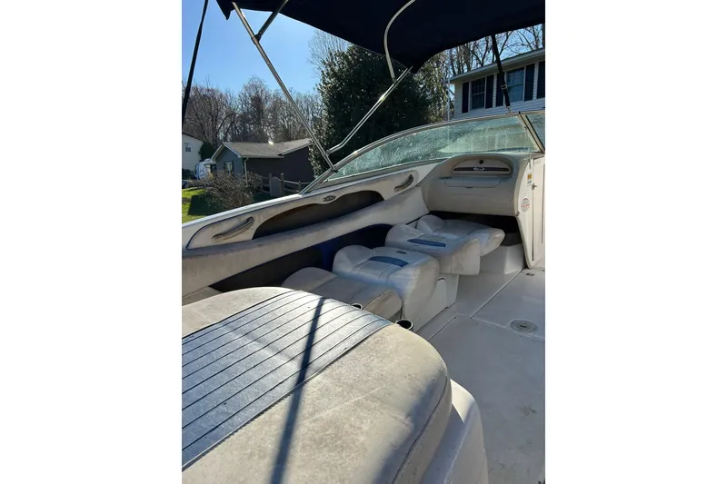 Slide: The Image of 2003 Chaparral 21 SSi boat interior with seating and canopy, parked outdoors. - 10