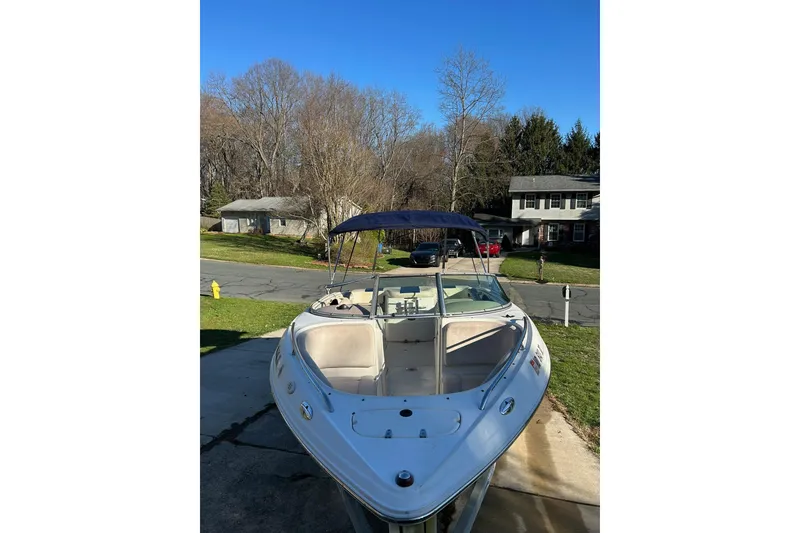 Slide: The Image of 2003 Chaparral 21 SSi boat with blue canopy parked in suburban driveway. - 14