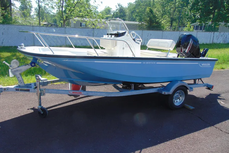 The Image of 2026 Boston Whaler 150 Montauk boat on trailer, parked outdoors. - 1