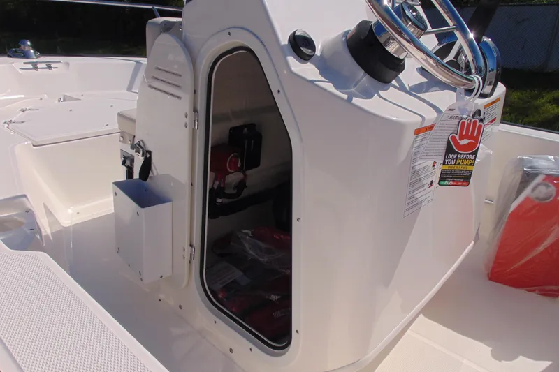 Slide: The Image of 2026 Boston Whaler 150 Montauk boat console with open storage compartment. - 12