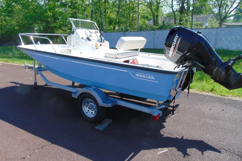 Slide: The Image of 2026 Boston Whaler 150 Montauk boat on trailer, featuring a Mercury outboard motor. - 2