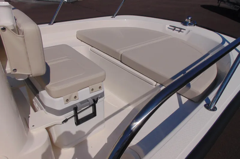 Slide: The Image of 2026 Boston Whaler 150 Montauk boat interior with cushioned seating and stainless steel railing. - 6