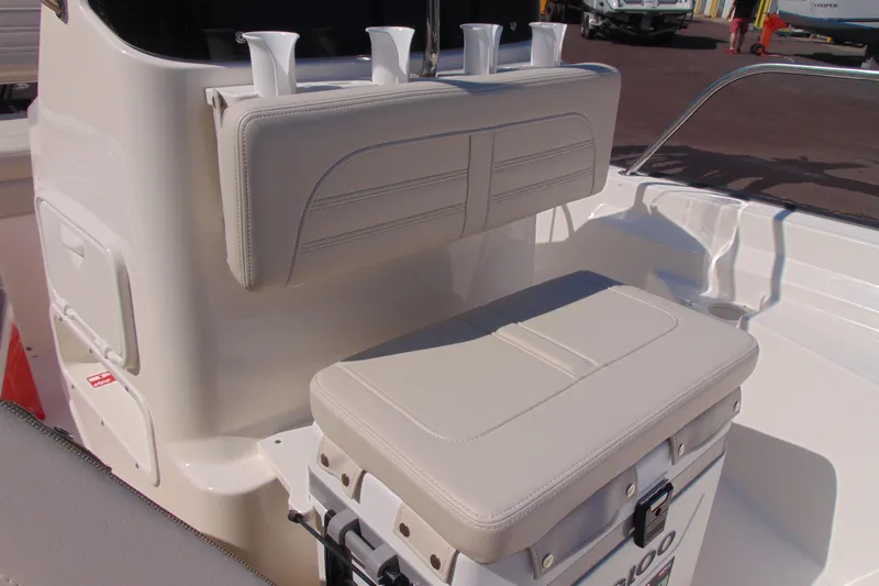 Slide: The Image of 2026 Boston Whaler 150 Montauk boat interior with cushioned seating and rod holders. - 9