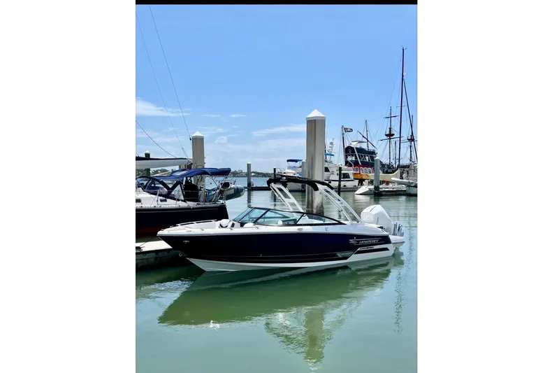 Slide: The Image of 2023 Monterey 235SS Super Sport boat docked at a marina under clear skies. - 2