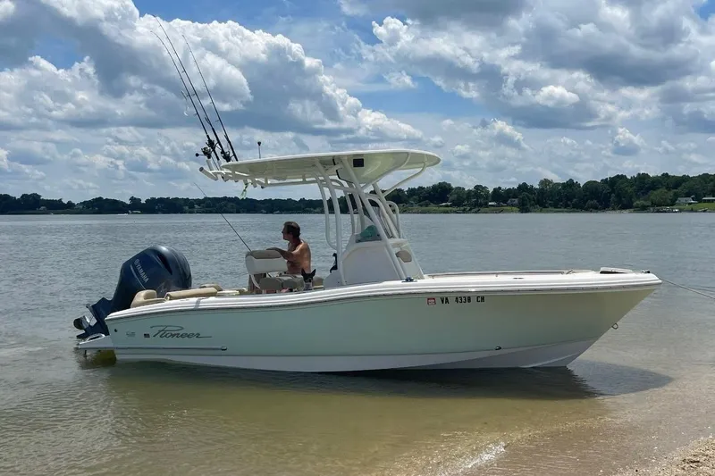The Image of 2020 Pioneer 202 Islander boat on a calm lake with fishing rods. - 0