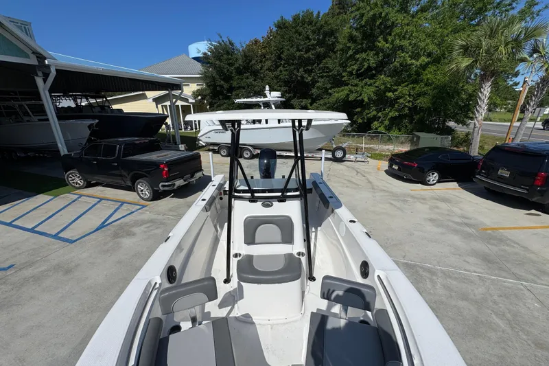 Slide: The Image of 2027 Sea Born LX21 Center Console boat parked in a marina with surrounding vehicles. - 19