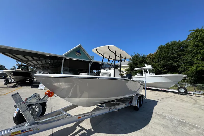 Slide: The Image of 2027 Sea Born LX21 Center Console boat on trailer under clear blue sky. - 3