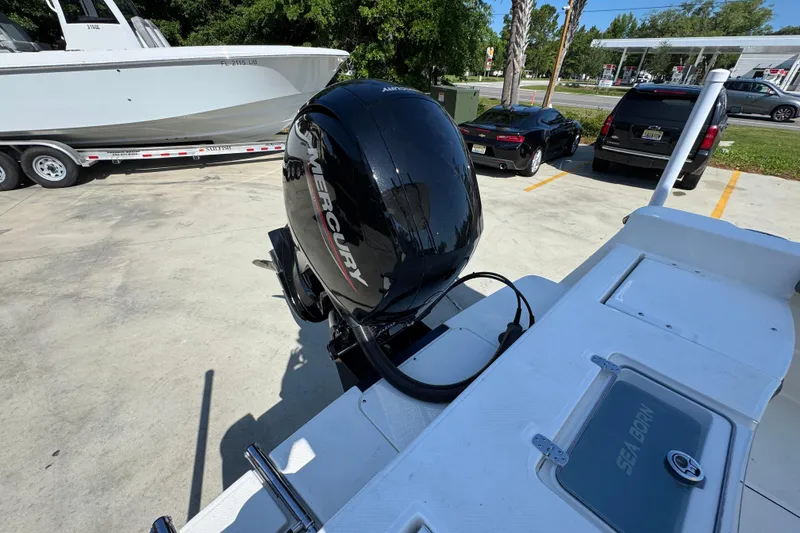 Slide: The Image of 2027 Sea Born LX21 Center Console with Mercury outboard motor in parking lot. - 32