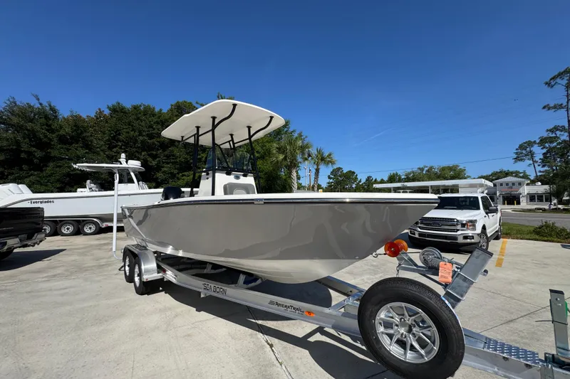 Slide: The Image of 2027 Sea Born LX21 Center Console boat on trailer in sunny outdoor setting. - 6