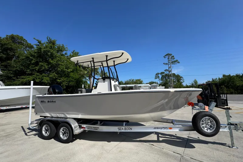 Slide: The Image of 2027 Sea Born LX21 Center Console boat on trailer, parked outdoors under clear blue sky. - 7
