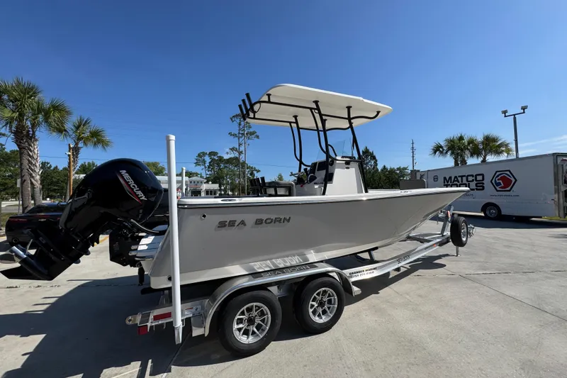 Slide: The Image of 2027 Sea Born LX21 Center Console boat on trailer, parked outdoors under clear blue sky. - 9