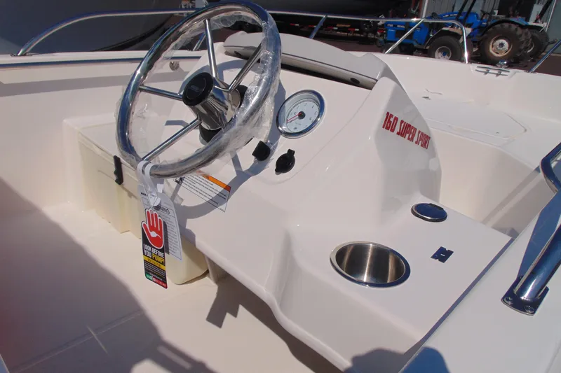 Slide: The Image of 2026 Boston Whaler 160 Super Sport boat dashboard with steering wheel and gauge. - 7