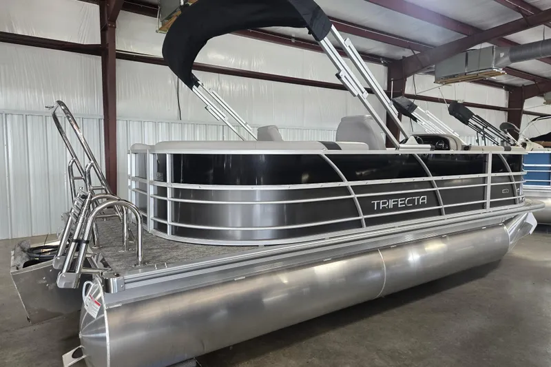Slide: The Image of 2025 Trifecta 20RF LE pontoon boat in a warehouse setting. - 2