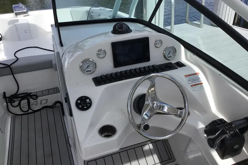 Slide: The Image of 2020 Twin Vee 240 DC GF boat dashboard with steering wheel and controls. - 12