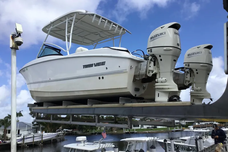 Slide: The Image of 2020 Twin Vee 240 DC GF boat with dual Suzuki engines on a lift. - 21