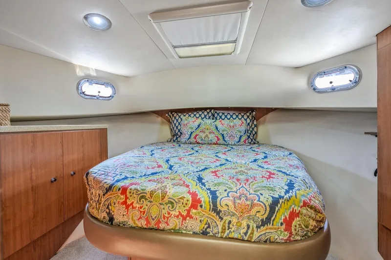 Slide: The Image of 2009 Mainship 40 Expedition cabin with colorful bedding and wooden cabinetry. - 40