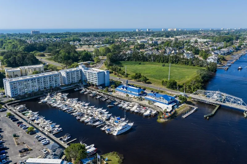 Slide: The Image of Aerial view of marina with boats, including a 2009 Mainship 40 Expedition, near waterfront buildings. - 17