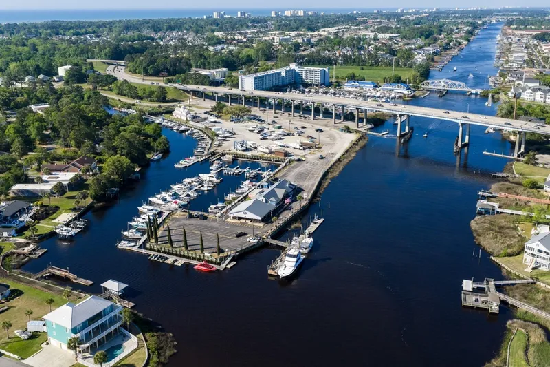 Slide: The Image of Aerial view of marina with boats, including a 2009 Mainship 40 Expedition, near a bridge and waterfront homes. - 15
