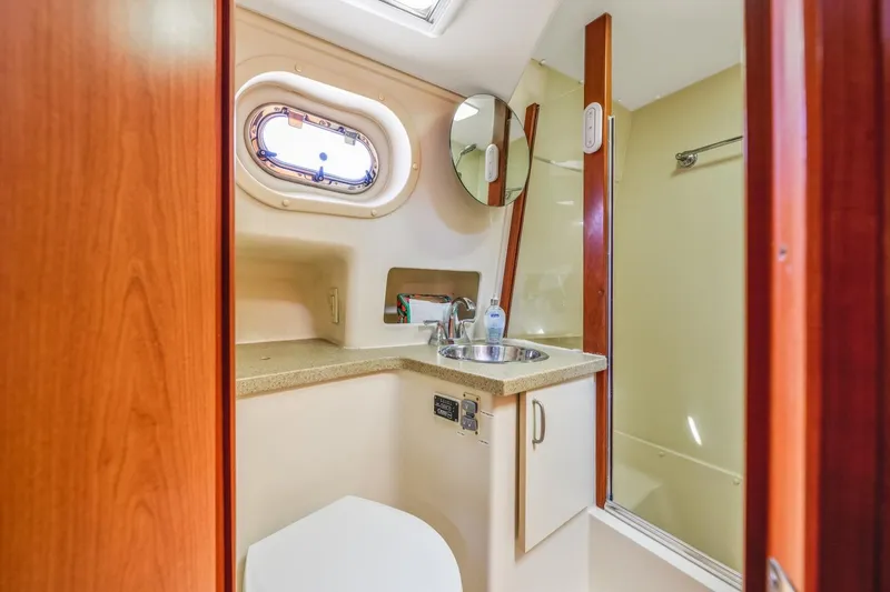 Slide: The Image of 2009 Mainship 40 Expedition yacht bathroom with sink, mirror, and porthole window. - 37