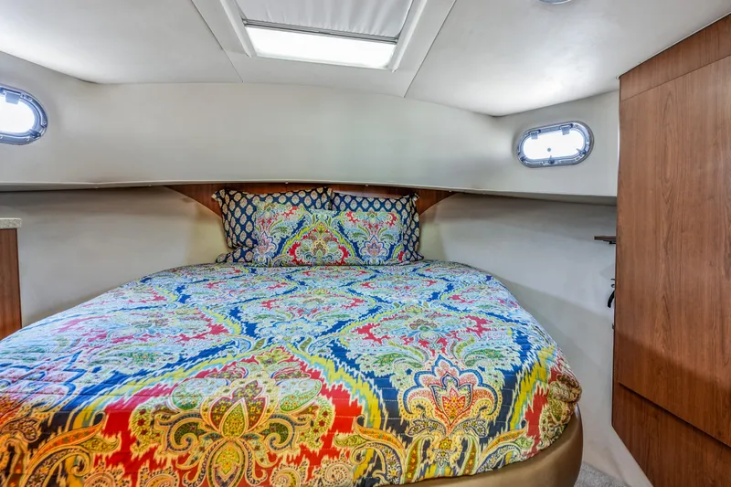 Slide: The Image of Cozy cabin bedroom in 2009 Mainship 40 Expedition with colorful bedding and porthole windows. - 25