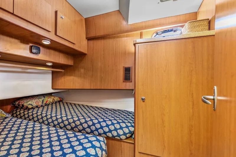 Slide: The Image of Cozy cabin interior of 2009 Mainship 40 Expedition with twin beds and wooden cabinetry. - 34