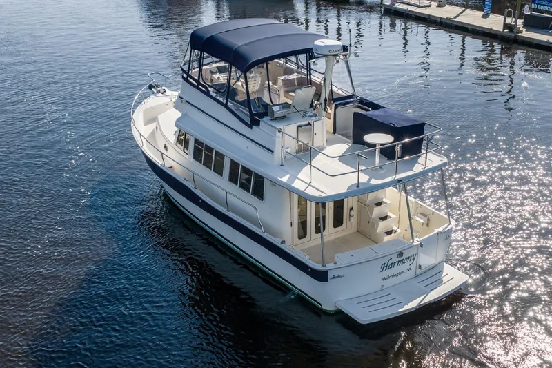 Slide: The Image of 2009 Mainship 40 Expedition yacht on water, featuring spacious deck and elegant design. - 13