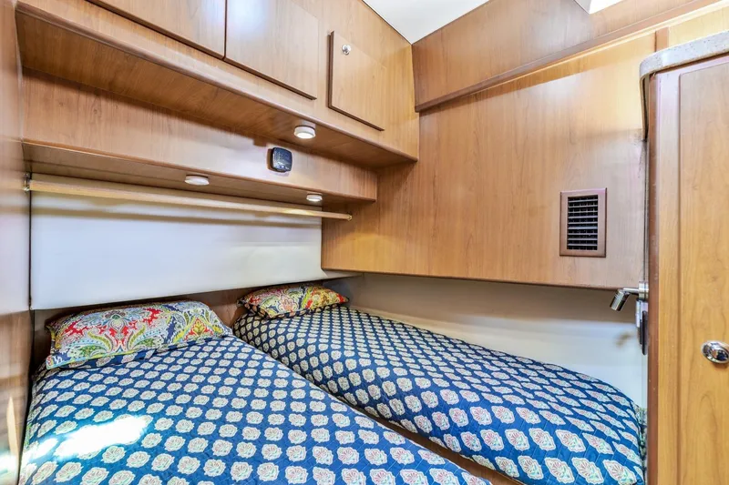 Slide: The Image of Twin beds in a 2009 Mainship 40 Expedition cabin with patterned bedding. - 36