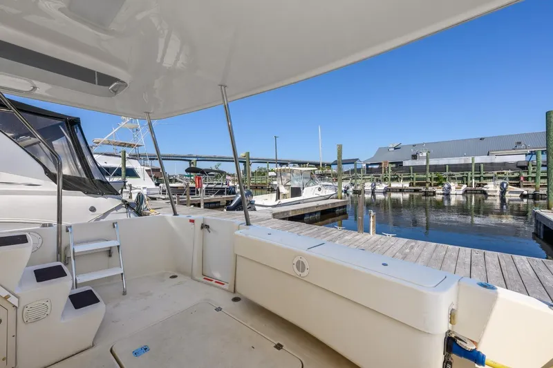 Slide: The Image of 2009 Mainship 40 Expedition yacht docked at marina, showcasing spacious deck and serene waterfront. - 20