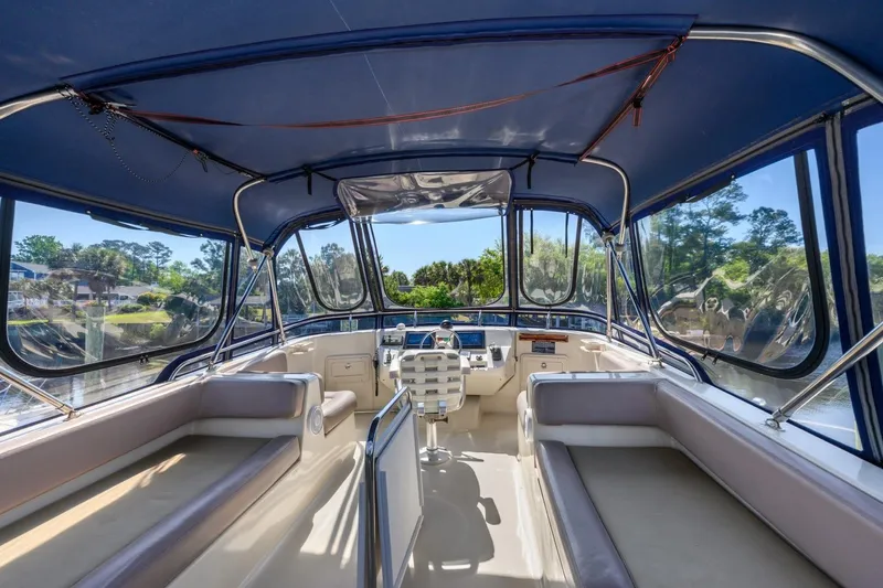 Slide: The Image of 2009 Mainship 40 Expedition boat interior with seating and helm, featuring blue canopy. - 31
