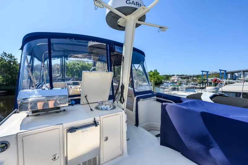 Slide: The Image of 2009 Mainship 40 Expedition boat with blue canopy, docked at marina. - 16
