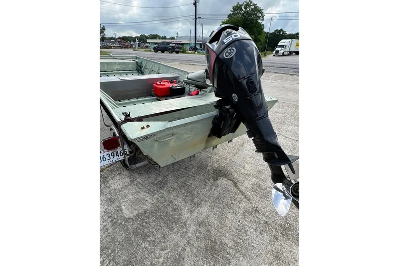 Slide: The Image of 1992 Weldcraft 1648 boat with outboard motor, parked on concrete surface. - 3