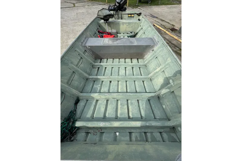 Slide: The Image of 1992 Weldcraft 1648 boat interior with metal bench and motor, parked on concrete. - 4