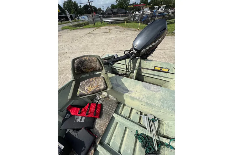 Slide: The Image of 1992 Weldcraft 1648 boat with camo seats and Evinrude motor, docked outdoors. - 7