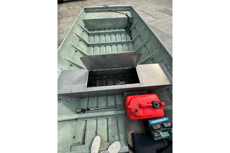 Slide: The Image of 1992 Weldcraft 1648 boat interior with storage compartment, red fuel tank, and battery. - 8