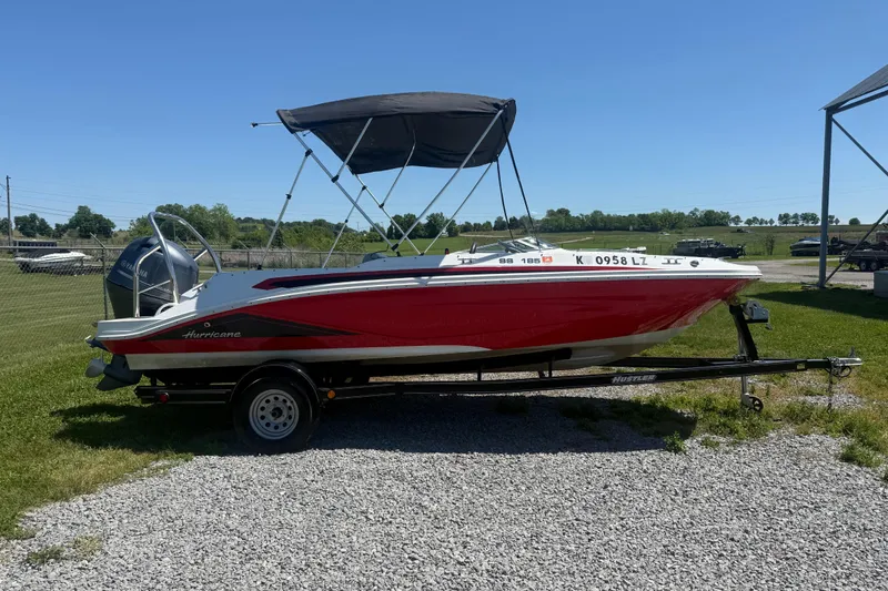 The Image of 2020 Hurricane SunDeck Sport 185 OB boat on trailer, red and white design, outdoor setting. - 1