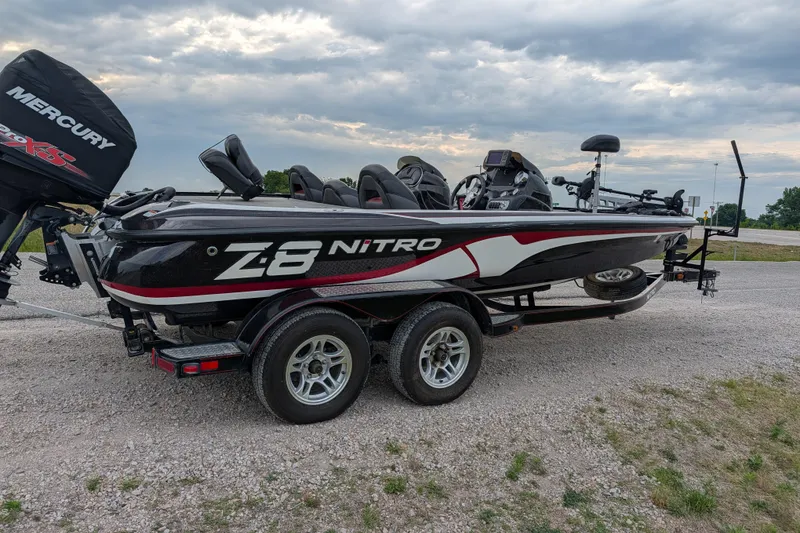 Slide: The Image of 2011 Nitro Z-8 boat with Mercury engine on a trailer, parked on gravel. - 43