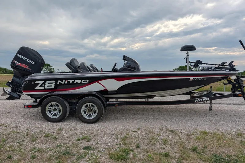 Slide: The Image of 2011 Nitro Z-8 boat with Mercury engine on a trailer, parked outdoors. - 44