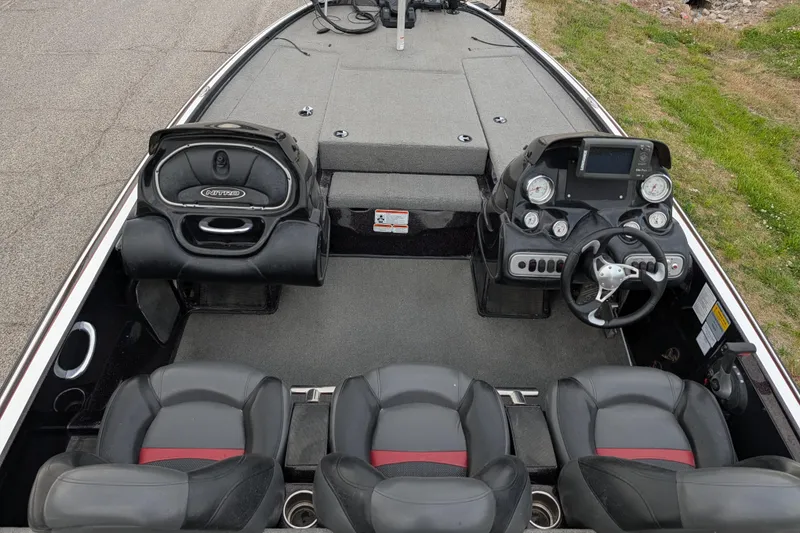 Slide: The Image of 2011 Nitro Z-8 boat interior with steering console and seating, parked on grass. - 52