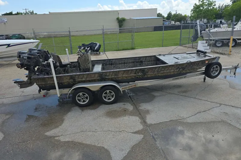 Slide: The Image of 2021 Prodrive 2060 boat on trailer, parked outdoors, featuring camouflage design and outboard motor. - 4