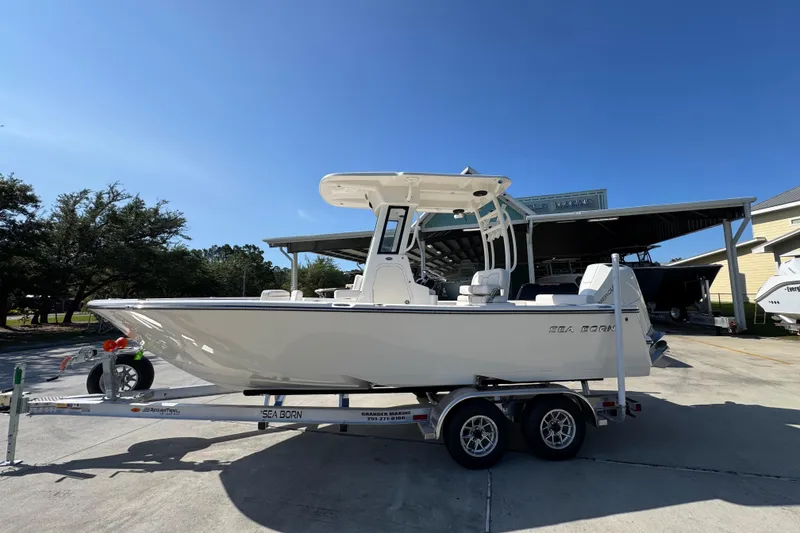 The Image of 2027 Sea Born LX22 Center Console boat on trailer under clear blue sky. - 1