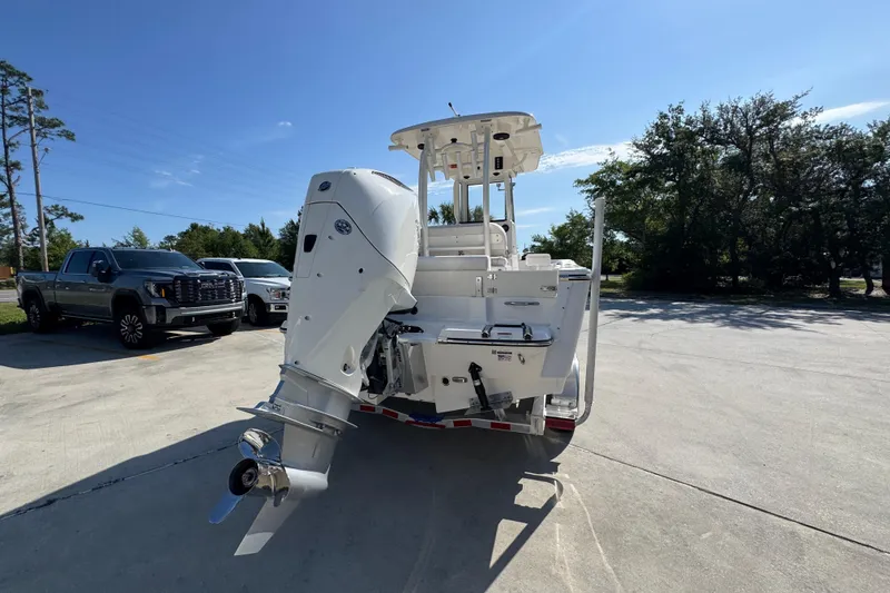 Slide: The Image of 2027 Sea Born LX22 Center Console boat with powerful outboard motor in a sunny parking lot. - 11