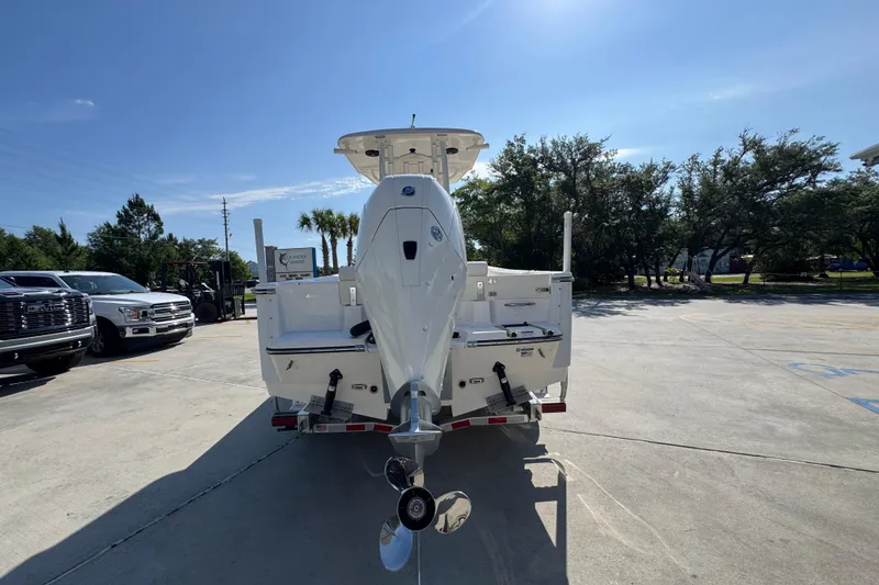 Slide: The Image of 2027 Sea Born LX22 Center Console boat on trailer, parked outdoors under clear sky. - 12