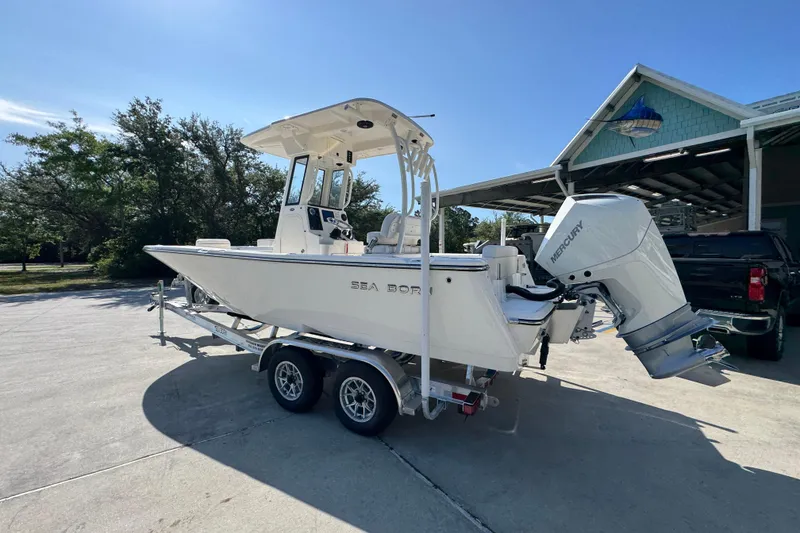 Slide: The Image of 2027 Sea Born LX22 Center Console boat on trailer, parked outdoors. - 15