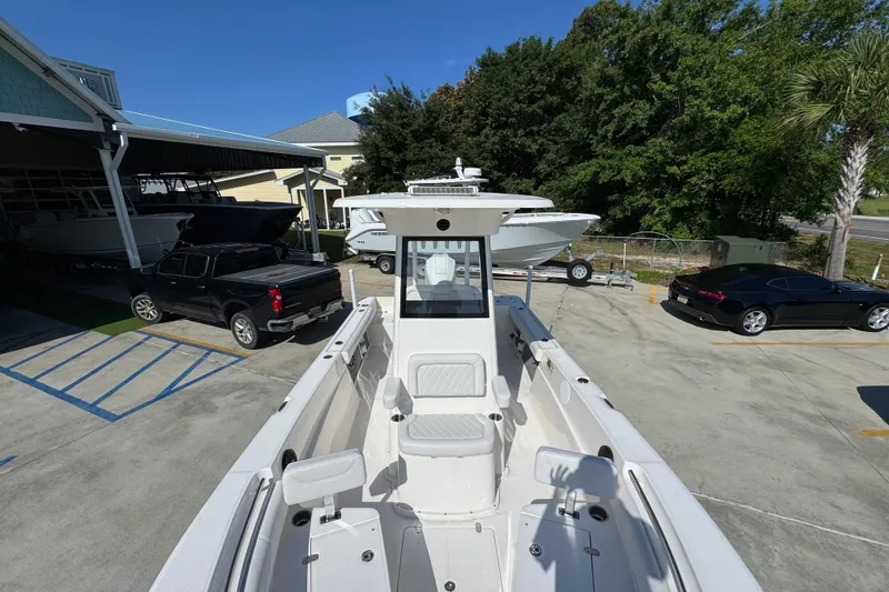 Slide: The Image of 2027 Sea Born LX22 Center Console boat in a parking lot with cars and trees. - 20