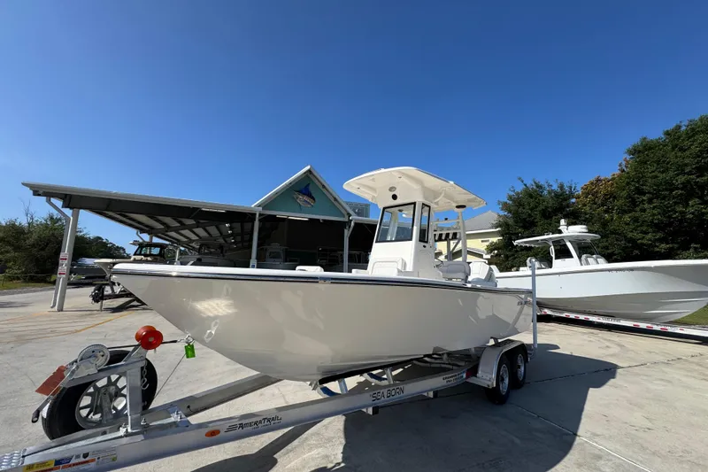 Slide: The Image of 2027 Sea Born LX22 Center Console boat on trailer, parked outdoors under clear blue sky. - 3
