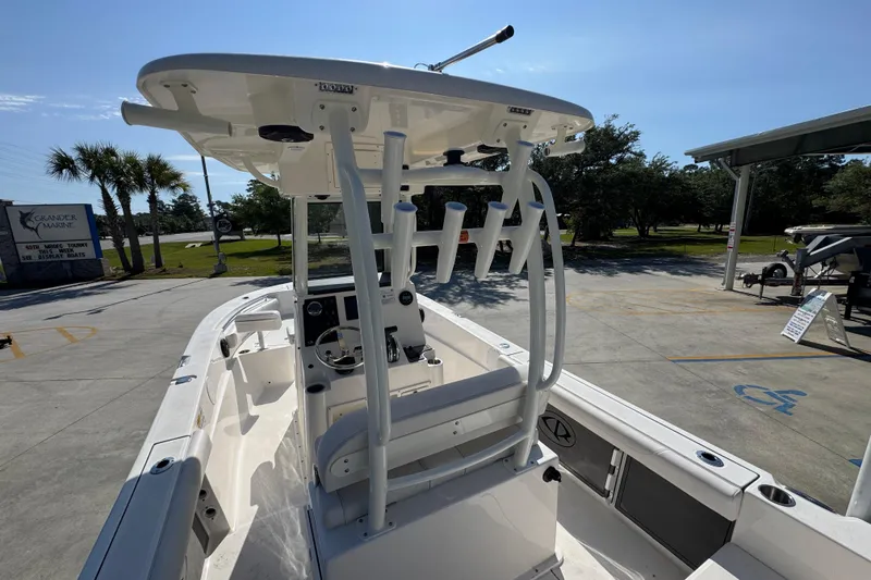 Slide: The Image of 2027 Sea Born LX22 Center Console boat with T-top and rod holders in a marina setting. - 32