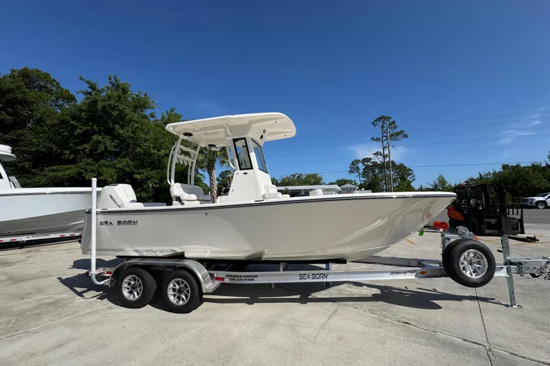 Slide: The Image of 2027 Sea Born LX22 Center Console boat on trailer under clear blue sky. - 7